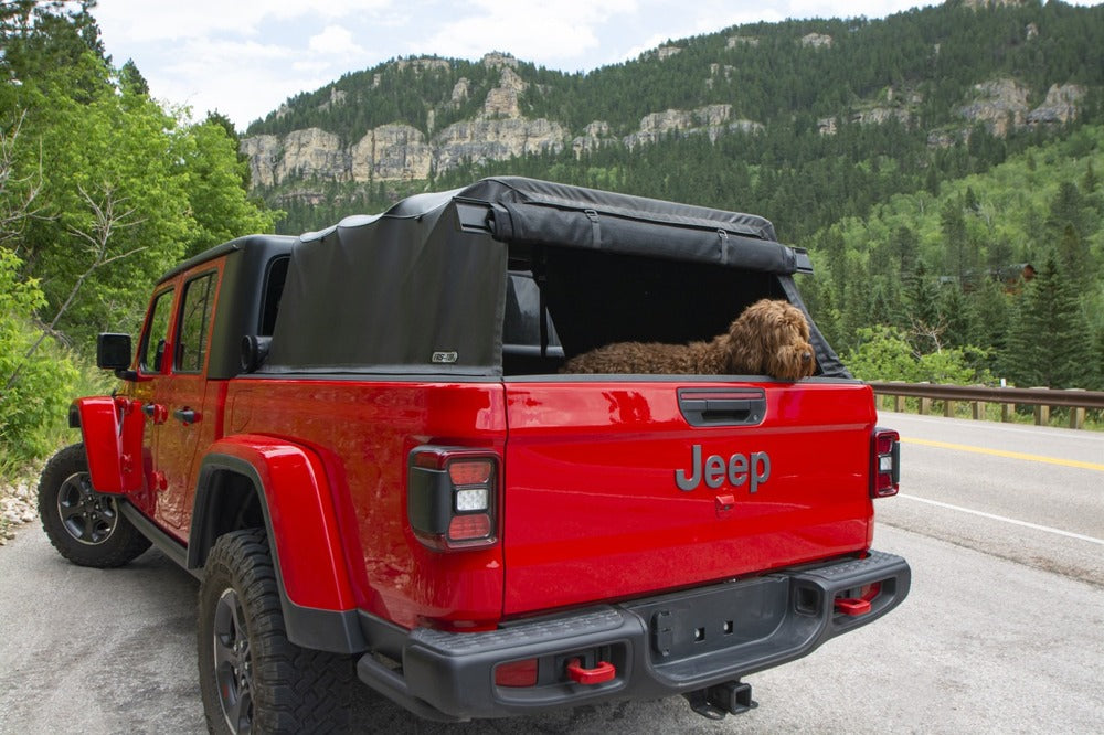 Installed Fas-Top Traveler Truck Tonneau & Topper For Jeep With A Dog Sitting Inside It