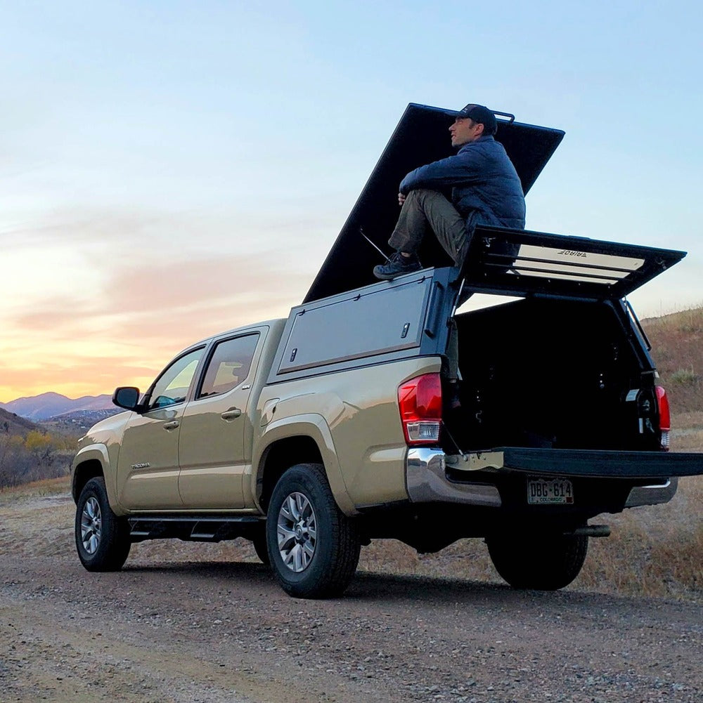 A Person Sitting On Top Of The GAIA Campers Tacoma Truck Cap