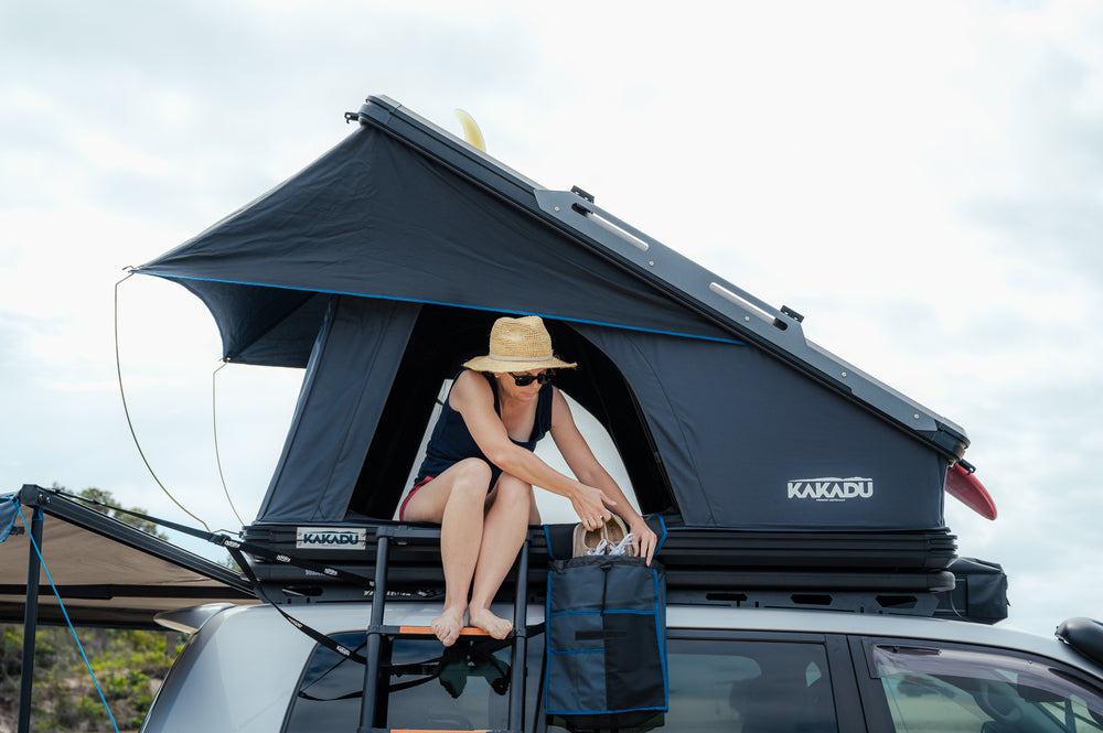 A Person Sitting In The Canning Roof Top Tent