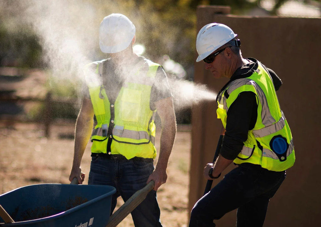 Construction workers using the misting vest from extrememist to cool off during their job