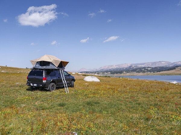 Front Runner Roof Top Tent On The Roof Rack Of A Vehicle That Is On The Plains FIeld
