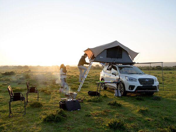 Person Climbing Inside Of A Front Runner Roof Top Tent That Is Setup On A Vehicle