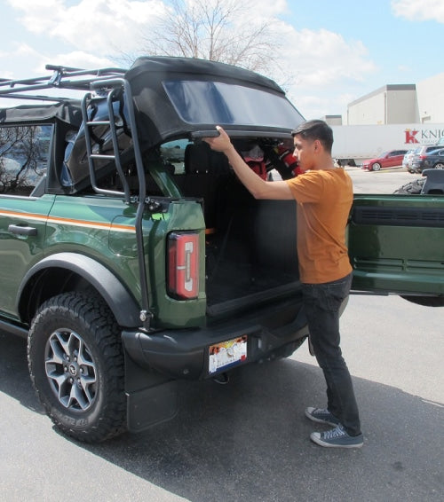 Image showing a man using the full capabilites of the gobi stealth rack mounted on ford bronco
