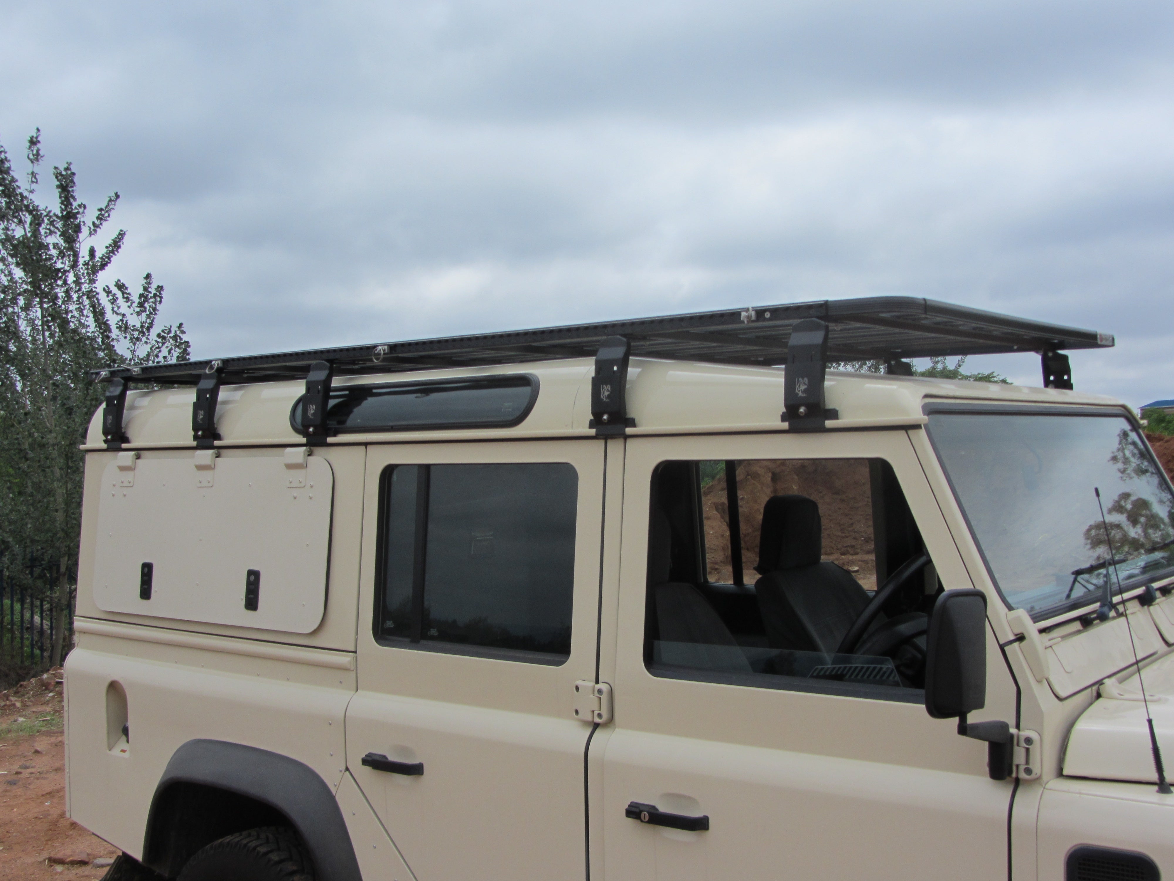 Eezi-Awn K9 roof rack kit mounted on Land Rover Defender 110 expedition build low-profile welded aluminum platform