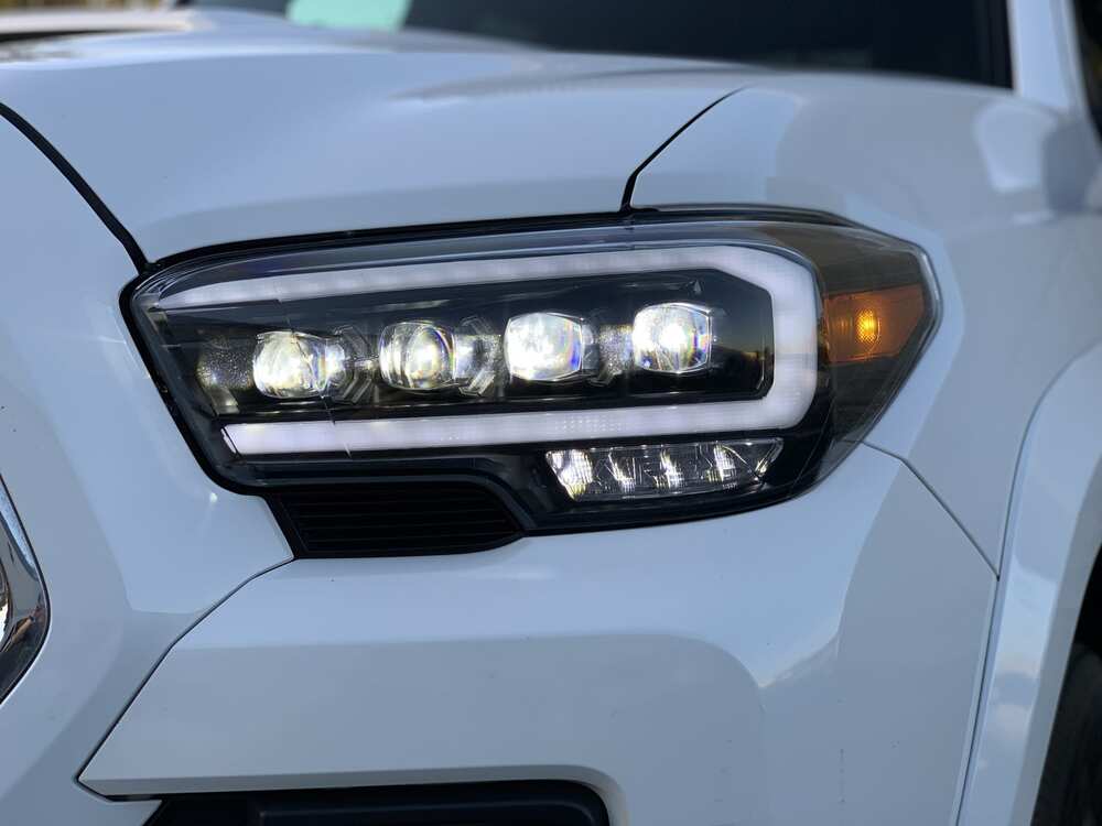 Close Up View Of The AlphaRex NOVA Series LED Headlights Mounted On A Tacoma And Turned On