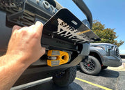 Lifting the flip up license plate bracket for Backwoods Adventure Mods Hi-Lite Series high clearance off road front bumpers to show hawse fairlead and winch