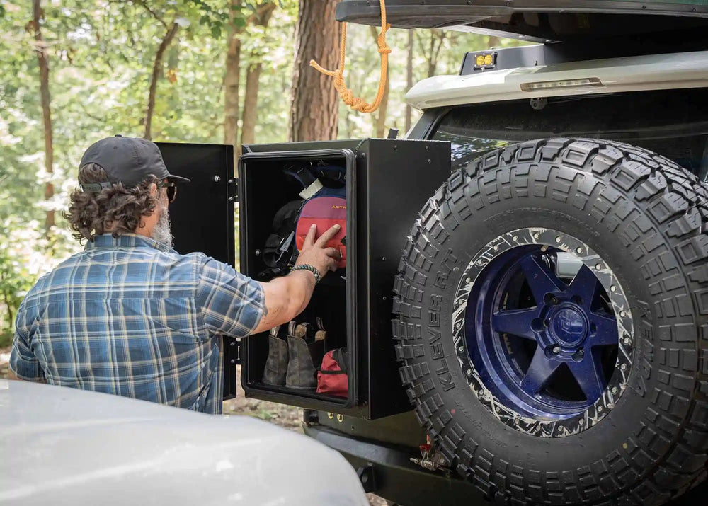 Person accessing hiking gear stored in Backwoods Adventure Mods Overland Storage Box