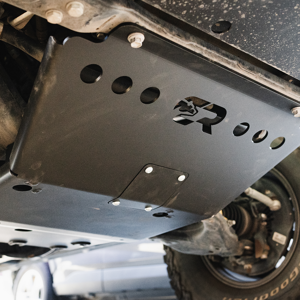 Cali Raised LED complete skid plate collection installed under a Toyota Tacoma showing front, transmission, transfer case and fuel tank plates