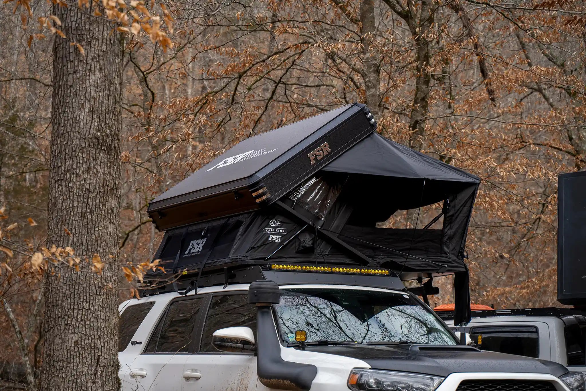 Freespirit Recreation Kali King hybrid foldout rooftop tent deployed on a vehicle at camp