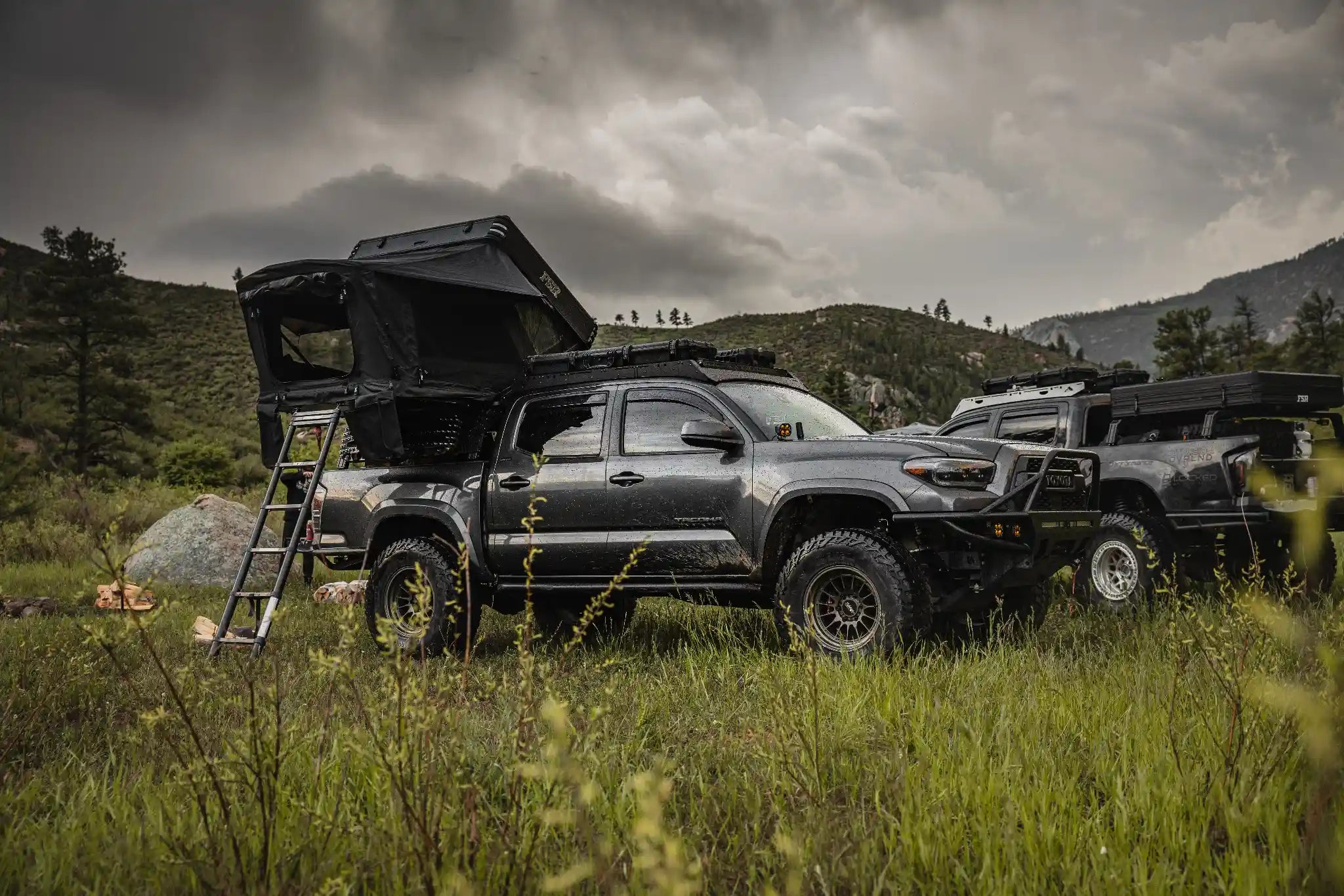 FSR Kali dual-hinge pop up rooftop tent deployed on a Toyota Tacoma in a mountain landscape