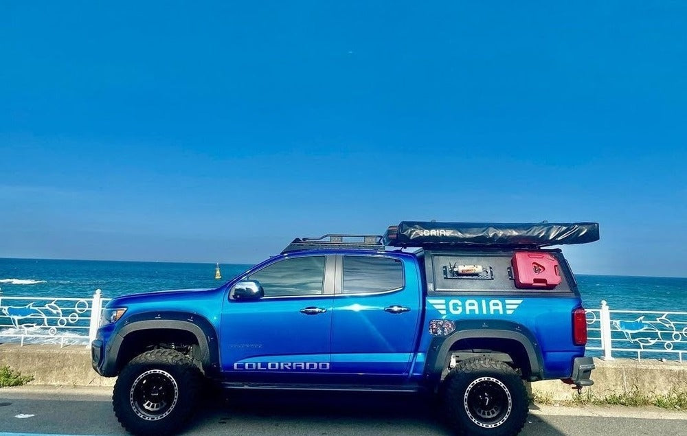 Side View Of The GAIA Campers Truck Top Installed On The Chevy Colorado With Mounted Accessories And An Awning