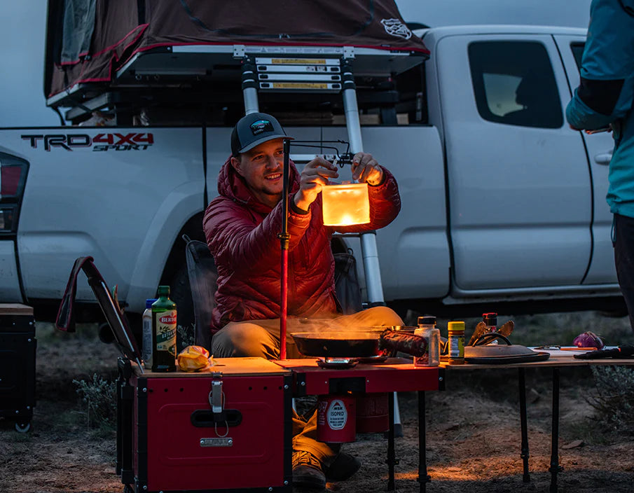 Image showing a man using the ikamper light stand to attach a lantern