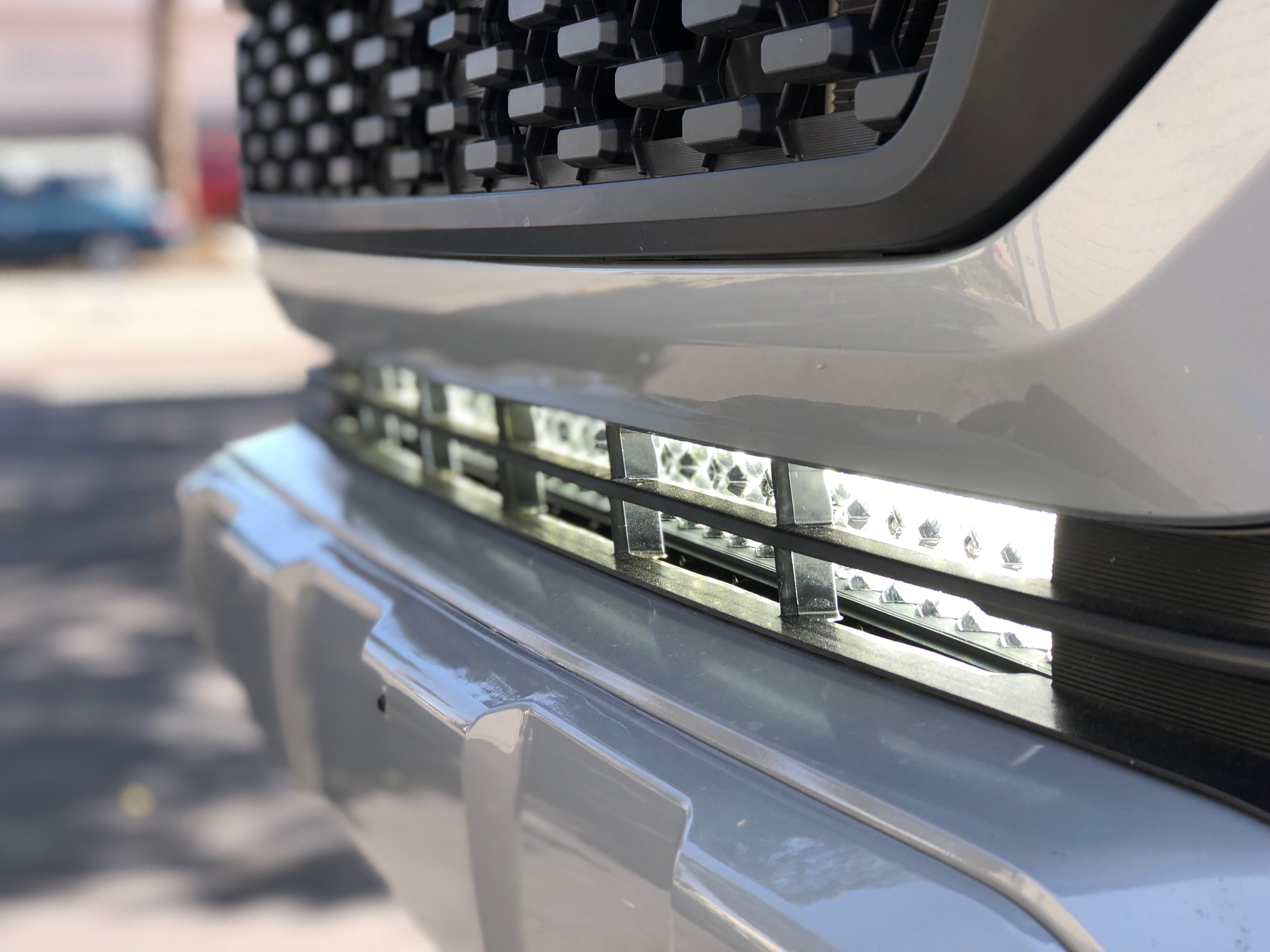Cali Raised LED 32 inch hidden LED light bar mounted behind the lower grille of a Toyota Tacoma