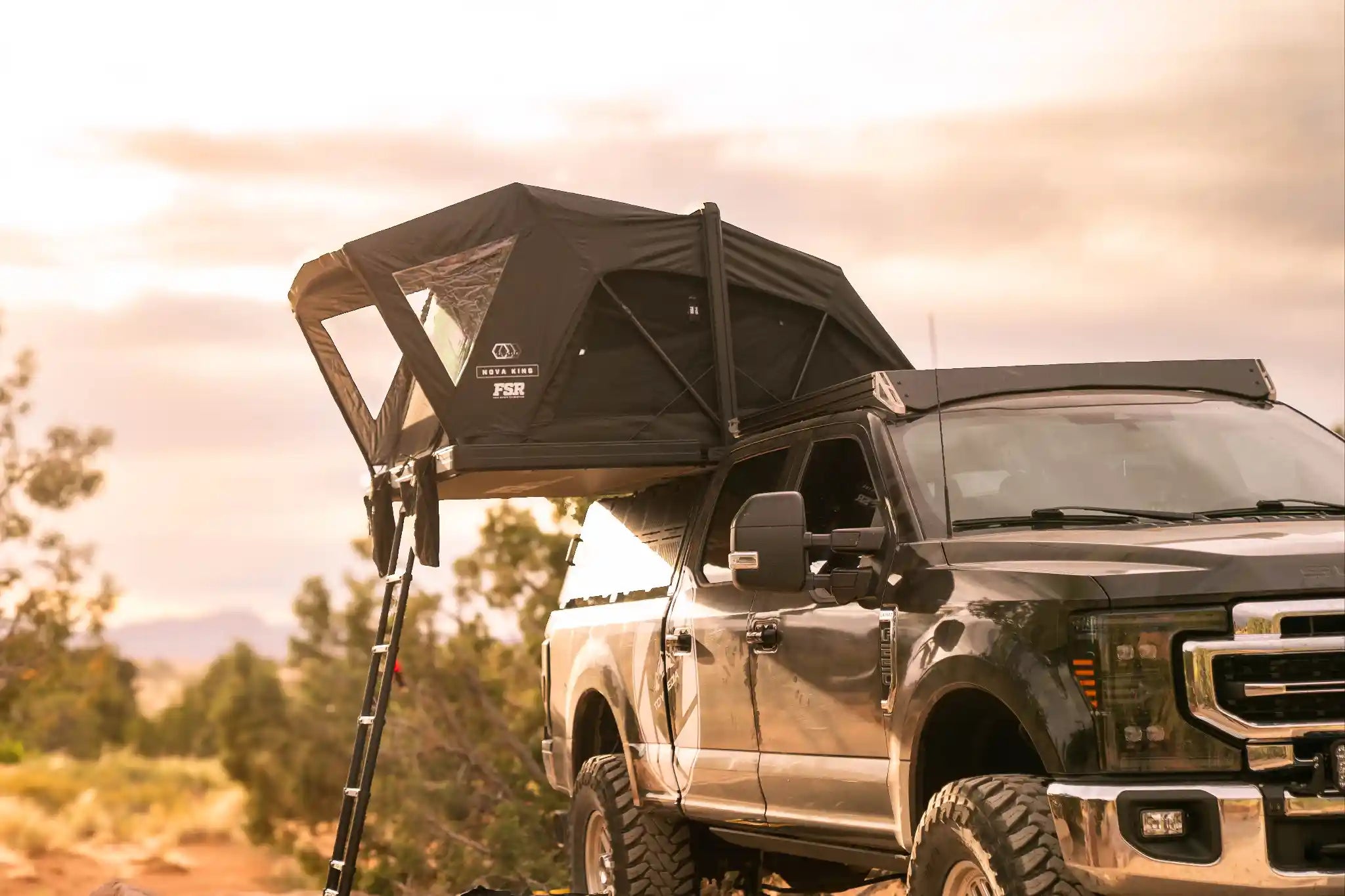 FSR Nova King hardshell foldout rooftop tent deployed on a Ford Super Duty above cab rack