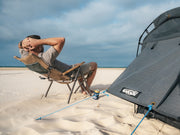 Person Sitting On A Chair Next To The Kakadu Sundowner Swag Tent