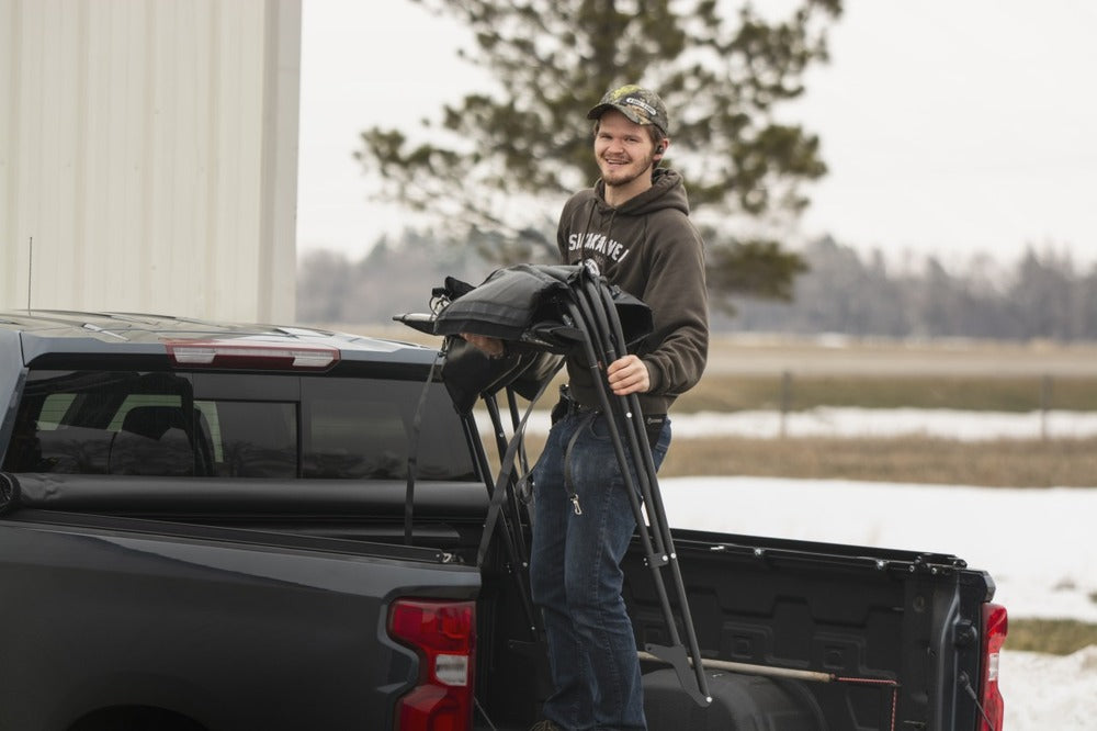 A Person Setting Up The Dodge/Ram Fas-Top Solo Soft Truck Topper