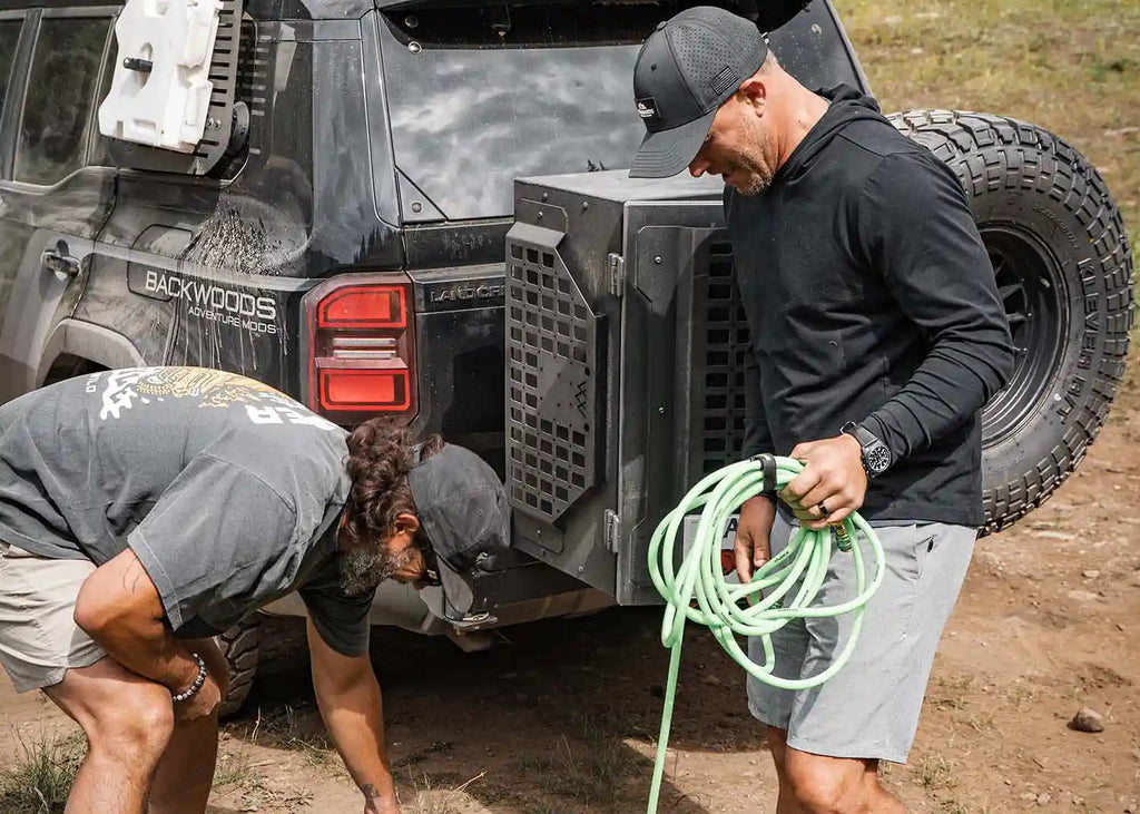 Men removing gear from Backwoods Overland Storage Box on Land Cruiser 250