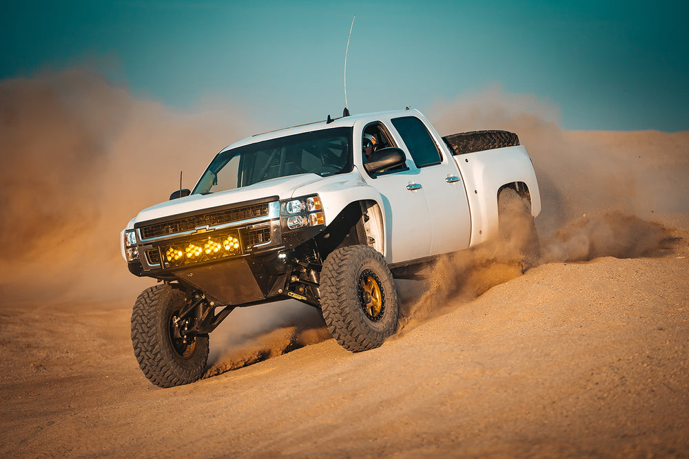 Baja Designs LP6 Pro LED light in Amber on a white pickup in the dessert.