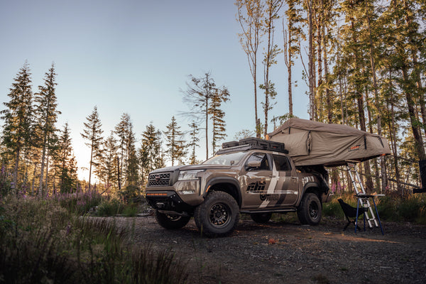 Nissan frontier with a mounted CBI front bumper parked with a deployed roof top tent