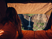 A Camper Looking At A Waterfall Through The The Front Runner Roof Top Tent Entrance